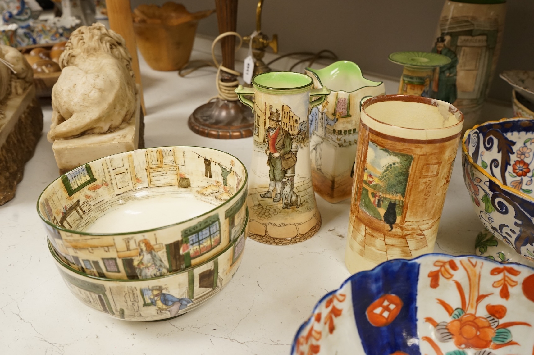 A collection of French, Japanese and English ceramics to include Royal Doulton Dickensware, Imari bowls and a faience glazed cat